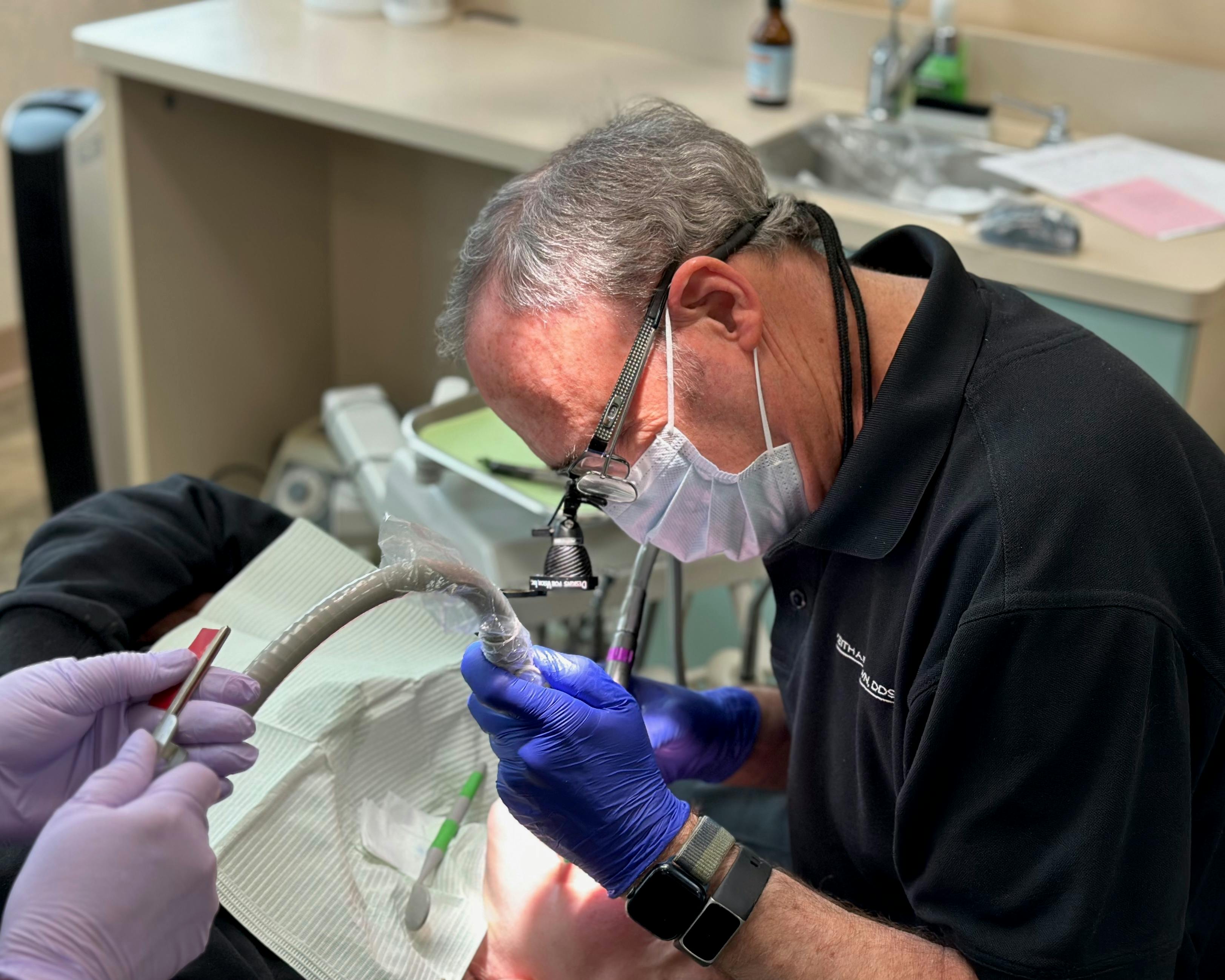 Close-up of Dr. Keith A. Brown DDS, FAGD, performing a dental procedure on a patient.