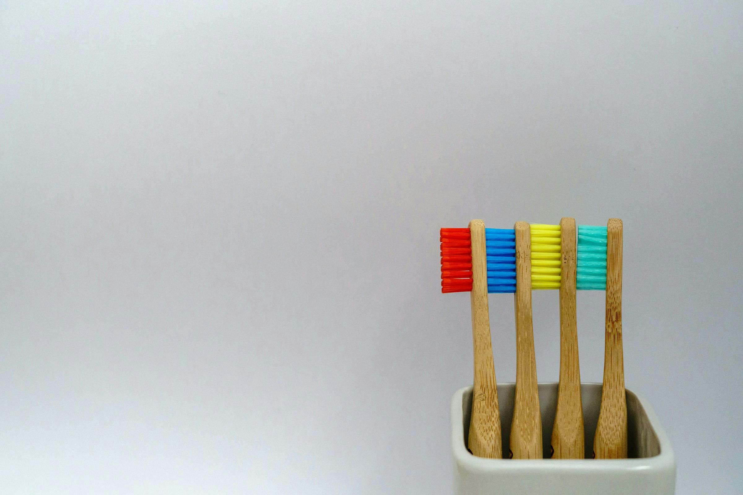 An assortment of colorful toothbrushes with bamboo handles, promoting eco-friendly dental hygiene