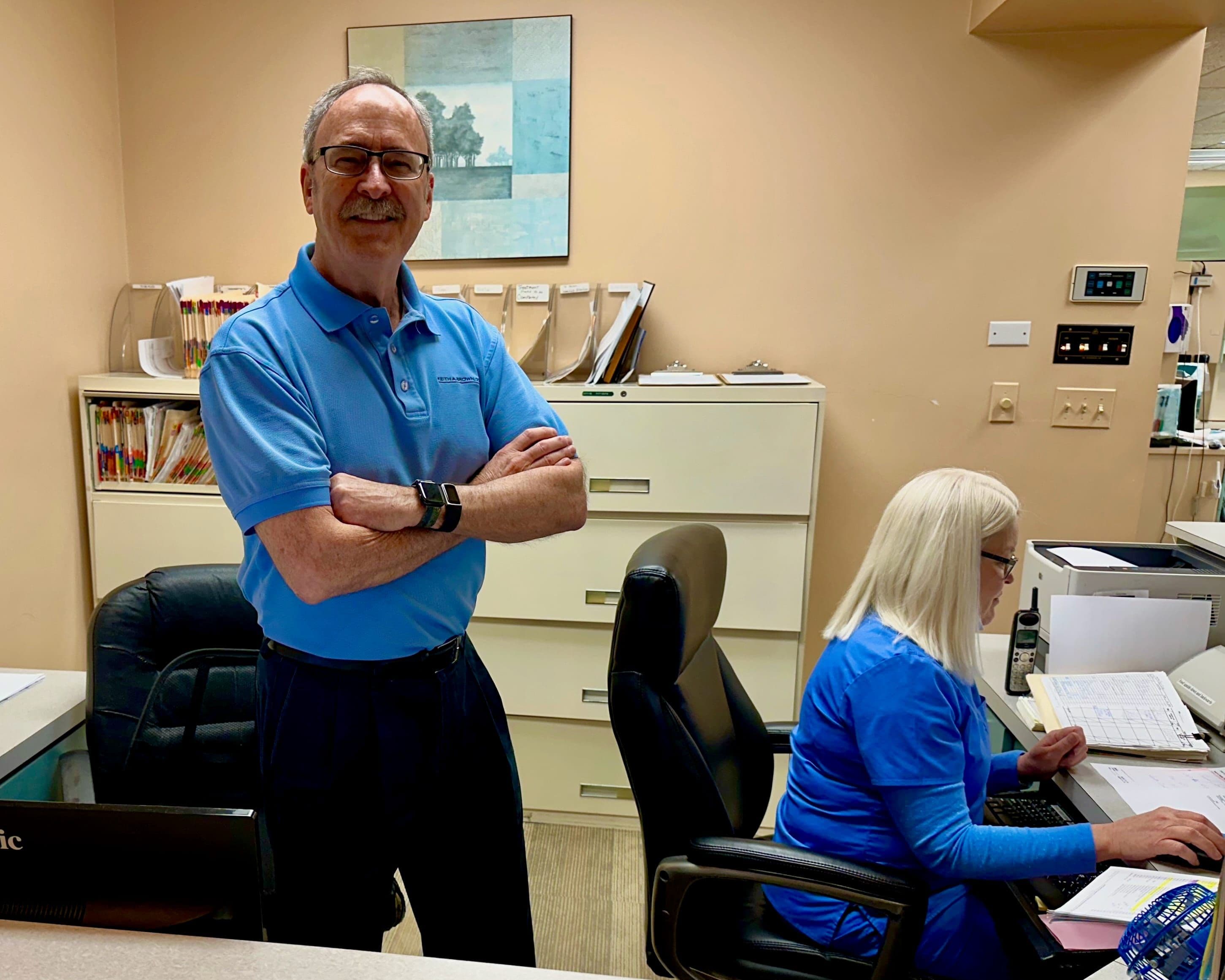 Dr. Keith A. Brown at the reception desk, welcoming patients